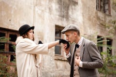 Gangsters. Against the background of an abandoned building in the forest, a man kisses a woman`s hand. royalty free stock photography Gangsters. Against the background of an abandoned building in the forest, a man kisses a woman`s hand. royalty free stock photography