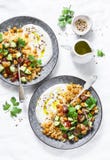 Garbanzos y cuscús condimentados con la ensalada y el yogur griego en un fondo blanco, visión superior del ` s del pastor imagenes de archivo Garbanzos y cuscús condimentados con la ensalada y el yogur griego en un fondo blanco, visión superior del ` s del pastor imagenes de archivo
