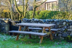 Garden picnic bench covered in morning frost in Stainforth, North Yorkshire