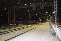 Gare ferroviaire de nuit snowfall Les lumières de la ville à l'arrière-plan photos stock Gare ferroviaire de nuit snowfall Les lumières de la ville à l'arrière-plan photos stock