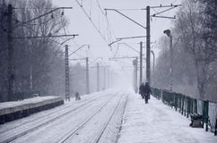 Gare ferroviaire vide en chutes de neige lourdes avec le brouillard épais Les rails ferroviaires entrent loin dans un brouillard photos libres de droits Gare ferroviaire vide en chutes de neige lourdes avec le brouillard épais Les rails ferroviaires entrent loin dans un brouillard photos libres de droits