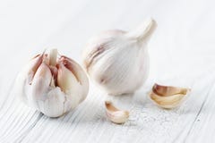 Garlic bulbs with garlic cloves on white rustic wood. stock photos Garlic bulbs with garlic cloves on white rustic wood. stock photos