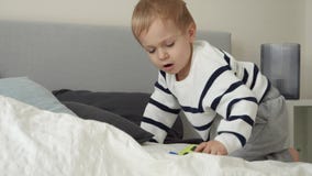 menino bonitinho arrumando a cama arrumando travesseiro e capa de