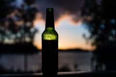 Garrafa de cerveja feita do vidro verde que obstrui a luz solar foto de stock Garrafa de cerveja feita do vidro verde que obstrui a luz solar foto de stock