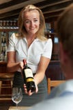 Garrafa de Showing Restaurant Customer da empregada de mesa do vinho tinto fotografia de stock royalty free Garrafa de Showing Restaurant Customer da empregada de mesa do vinho tinto fotografia de stock royalty free