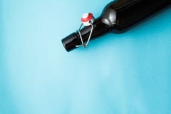 Garrafa marrom velha com cerveja sem uma etiqueta em um fundo azul Espa?o para o texto fotografia de stock Garrafa marrom velha com cerveja sem uma etiqueta em um fundo azul Espa?o para o texto fotografia de stock