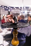 Garçom Prepares do servidor do cachimbo de água uma tubulação de Shisha para fumar um dos suportes da exposição foto de stock Garçom Prepares do servidor do cachimbo de água uma tubulação de Shisha para fumar um dos suportes da exposição foto de stock