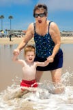 Garçon avec la grand-maman dans les vagues photo stock Garçon avec la grand-maman dans les vagues photo stock