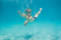 Garçon ayant l'amusement jouant sous l'eau dans la piscine des vacances d'été photos libres de droits Garçon ayant l'amusement jouant sous l'eau dans la piscine des vacances d'été photos libres de droits