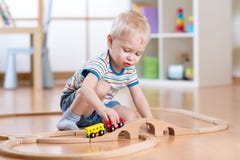Garçon d'enfant jouant dans sa chambre avec un train de jouet photo libre de droits Garçon d'enfant jouant dans sa chambre avec un train de jouet photo libre de droits