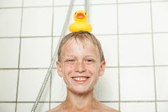 Garçon de sourire versant avec mignon en caoutchouc sur la tête photo stock Garçon de sourire versant avec mignon en caoutchouc sur la tête photo stock