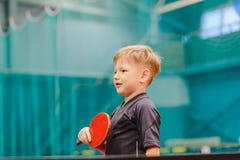 Garçon jouant le ping-pong dans le hall de tennis photographie stock Garçon jouant le ping-pong dans le hall de tennis photographie stock