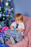Garçon mignon déballant des cadeaux de Noël photos stock Garçon mignon déballant des cadeaux de Noël photos stock
