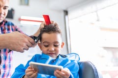 Garçon mignon obtenant une coupe de cheveux dans Barber Shop Concept de beauté photo stock Garçon mignon obtenant une coupe de cheveux dans Barber Shop Concept de beauté photo stock