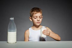 Garçon regardant le verre de lait photos libres de droits Garçon regardant le verre de lait photos libres de droits