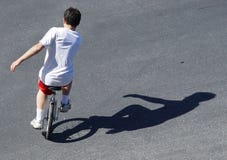 Garçon sur un unicycle photographie stock libre de droits Garçon sur un unicycle photographie stock libre de droits