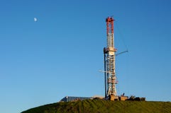 Gas Drill on Hilltop. This image shows the distant moon looking down on a Marcellus Shale natural gas drill Gas Drill on Hilltop. This image shows the distant moon looking down on a Marcellus Shale natural gas drill