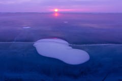 Gasblase eingefroren in das Eis vom Baikalsee in der violetten Dämmerung der Sonne stockfotografie Gasblase eingefroren in das Eis vom Baikalsee in der violetten Dämmerung der Sonne stockfotografie