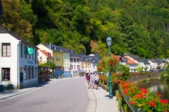 Gata i den gamla staden av Vianden, Luxembourg, i flodstranden med röda blommor på en sida arkivbilder Gata i den gamla staden av Vianden, Luxembourg, i flodstranden med röda blommor på en sida arkivbilder