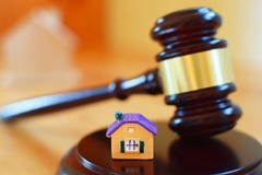 Gavel δικαστών στον υγιή φραγμό δίπλα στο κίτρινο ζωηρόχρωμο σπίτι στοκ φωτογραφία με δικαίωμα ελεύθερης χρήσης Gavel δικαστών στον υγιή φραγμό δίπλα στο κίτρινο ζωηρόχρωμο σπίτι στοκ φωτογραφία με δικαίωμα ελεύθερης χρήσης