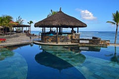 Gazebo bar next to a pool at tropical beach of a hotel resort