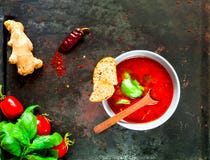 Gazpacho avec des ingrédients dans la cuvette bleue sur le fond foncé de cru de vieux métaux rouillés photographie stock libre de droits Gazpacho avec des ingrédients dans la cuvette bleue sur le fond foncé de cru de vieux métaux rouillés photographie stock libre de droits