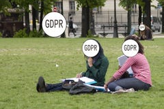 GDPR - duas meninas estão sentando-se na grama no parque, suas caras são escondidas pela proteção de dados geral da inscrição fotografia de stock royalty free GDPR - duas meninas estão sentando-se na grama no parque, suas caras são escondidas pela proteção de dados geral da inscrição fotografia de stock royalty free