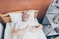 Gealterter Patient liegt im Bett und hält seine Hände nahe zu h lizenzfreie stockbilder Gealterter Patient liegt im Bett und hält seine Hände nahe zu h lizenzfreie stockbilder
