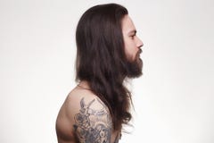 Gebaarde mens met lange haar en tatoegering royalty-vrije stock afbeelding Gebaarde mens met lange haar en tatoegering royalty-vrije stock afbeelding
