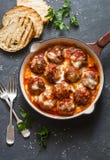 Gebakken varkensvleesvleesballetjes met mozarella en tomatensaus in een pan op een donkere achtergrond stock afbeelding Gebakken varkensvleesvleesballetjes met mozarella en tomatensaus in een pan op een donkere achtergrond stock afbeelding