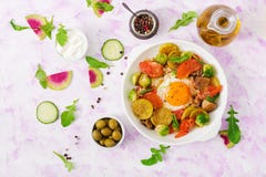 Gebraden eieren met groenten - shakshuka en verse saladekomkommer, watermeloenradijs en arugula Stock Afbeelding Gebraden eieren met groenten - shakshuka en verse saladekomkommer, watermeloenradijs en arugula Stock Afbeelding