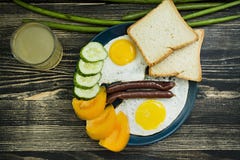 Gebraden eieren in plaat met kersentomaten, worsten en brood voor ontbijt stock afbeeldingen Gebraden eieren in plaat met kersentomaten, worsten en brood voor ontbijt stock afbeeldingen