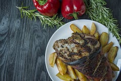 Gebratener Schweinefleischkn?chel mit Kartoffeln diente auf einer wei?en Platte Verzierte mit frischem bulgarischem Pfeffer, Rosm lizenzfreies stockbild Gebratener Schweinefleischkn?chel mit Kartoffeln diente auf einer wei?en Platte Verzierte mit frischem bulgarischem Pfeffer, Rosm lizenzfreies stockbild
