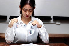 Gedeprimeerde verstoorde jonge Aziatische bedrijfs vrouwelijke tearing omhooggaande grafieken of administratie in bureau stock foto Gedeprimeerde verstoorde jonge Aziatische bedrijfs vrouwelijke tearing omhooggaande grafieken of administratie in bureau stock foto