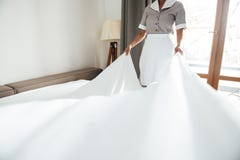 Geerntetes Bild ändernden Bettlaken des Hotelmädchens stockbild Geerntetes Bild ändernden Bettlaken des Hotelmädchens stockbild