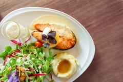 Gegrilltes Lachssteak geschnitten auf wei?er Platte mit Mischgem?sesalat, Kartoffelp?rees und Belag in einem Glas, Nahrung in ein stockbild Gegrilltes Lachssteak geschnitten auf wei?er Platte mit Mischgem?sesalat, Kartoffelp?rees und Belag in einem Glas, Nahrung in ein stockbild