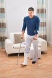 Gehandicapte mens die steunpilaren voor het lopen gebruiken stock afbeelding Gehandicapte mens die steunpilaren voor het lopen gebruiken stock afbeelding