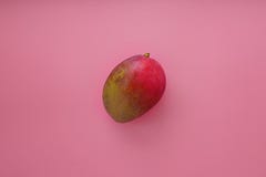 Gehele mango op een roze achtergrond stock fotografie Gehele mango op een roze achtergrond stock fotografie