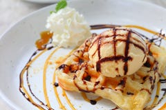 Gelato alla vaniglia della cialda sulla cima con cioccolato e sciroppo d'acero sul piatto bianco fotografia stock Gelato alla vaniglia della cialda sulla cima con cioccolato e sciroppo d'acero sul piatto bianco fotografia stock