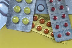 Gelbe runde Pille, Brown, dunkelrote Pillentabletten in einem Paket auf einem gelben Hintergrund stockbilder Gelbe runde Pille, Brown, dunkelrote Pillentabletten in einem Paket auf einem gelben Hintergrund stockbilder