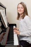 Gelukkig jong meisje dat de piano speelt Royalty-vrije Stock Afbeeldingen Gelukkig jong meisje dat de piano speelt Royalty-vrije Stock Afbeeldingen