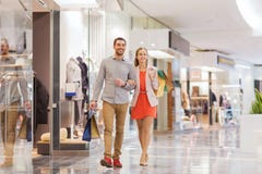 Gelukkig jong paar met het winkelen zakken in wandelgalerij royalty-vrije stock afbeelding Gelukkig jong paar met het winkelen zakken in wandelgalerij royalty-vrije stock afbeelding
