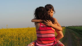 Gelukkig kind die moeder in aard koesteren Een vrouw met een baby koestert in gele bloemen Het mamma koestert haar dochter Emotie stock video Gelukkig kind die moeder in aard koesteren Een vrouw met een baby koestert in gele bloemen Het mamma koestert haar dochter Emotie stock video