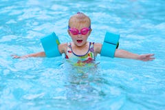 Gelukkig klein meisje die in de pool zwemmen royalty-vrije stock afbeelding Gelukkig klein meisje die in de pool zwemmen royalty-vrije stock afbeelding