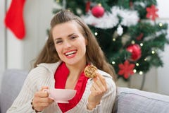 Gelukkig meisje dichtbij Kerstboom met kop en koekje royalty-vrije stock afbeelding Gelukkig meisje dichtbij Kerstboom met kop en koekje royalty-vrije stock afbeelding
