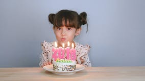 Gelukkig nieuw jaar 2018 leuk meisje met smileygezicht met cake het aantal van de slagkaars voor jaar 2018 op de nieuwe partij va stock video Gelukkig nieuw jaar 2018 leuk meisje met smileygezicht met cake het aantal van de slagkaars voor jaar 2018 op de nieuwe partij va stock video