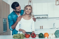 Gelukkig paar die ontbijt samen in keuken voorbereiden royalty-vrije stock afbeeldingen Gelukkig paar die ontbijt samen in keuken voorbereiden royalty-vrije stock afbeeldingen