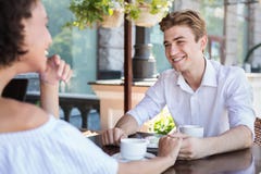 Gelukkig paar die tussen verschillende rassen bij de zomerterras flirten royalty-vrije stock foto Gelukkig paar die tussen verschillende rassen bij de zomerterras flirten royalty-vrije stock foto