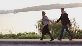 Gelukkig paar op de avondgang bij het meer Het meisje leidt vriend stock footage Gelukkig paar op de avondgang bij het meer Het meisje leidt vriend stock footage