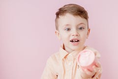 Gelukkig weinig jongen met een gift foto op roze achtergrond De glimlachende jongen houdt huidige doos Concept vakantie en verjaa stock foto Gelukkig weinig jongen met een gift foto op roze achtergrond De glimlachende jongen houdt huidige doos Concept vakantie en verjaa stock foto